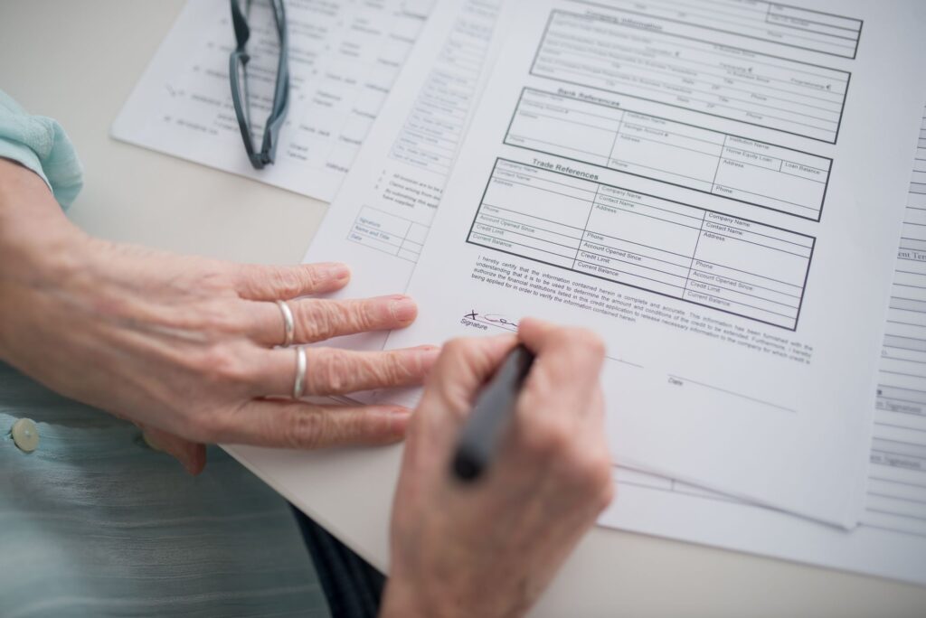 Business owner carefully reviewing and signing fields on an official registration document