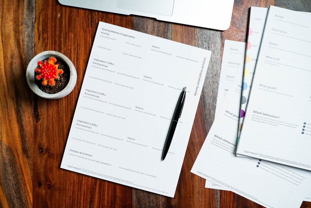 Organized paperwork and forms laid out on a wooden desk with a pen, representing the document preparation checklist for BIR Form 1901 registration