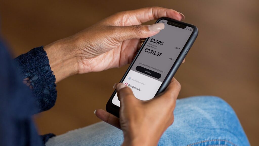 Hands holding a smartphone using a mobile banking app to transfer money, illustrating BIR ePay electronic tax payment through GCash and Maya