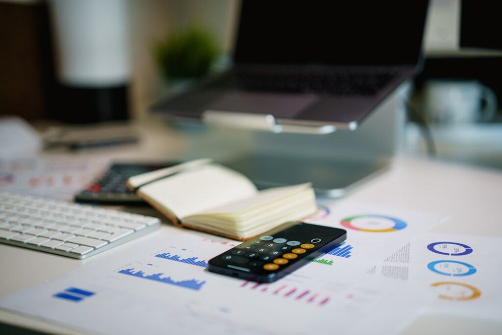 Calculator and financial charts on a desk for budgeting business registration fees