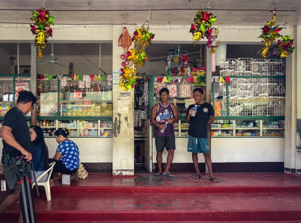Filipino small business owners gathered outside a sari-sari store in the Philippines, representing the SME businesses that need a Mayor's Permit in Davao City