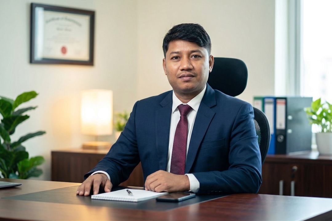 Professional lawyer in suit seated at office desk with diploma on wall — how to choose a law firm in Davao for your business