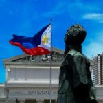 Philippine flag waving in front of a government building, representing the BPLO and Mayor's Permit process in Davao City