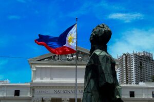 Philippine flag waving in front of a government building, representing the BPLO and Mayor's Permit process in Davao City