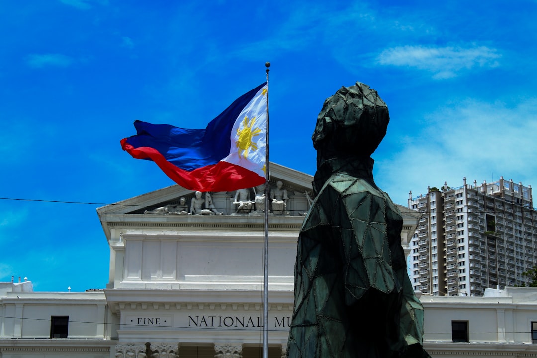 Philippine flag waving in front of a government building, representing the BPLO and Mayor's Permit process in Davao City